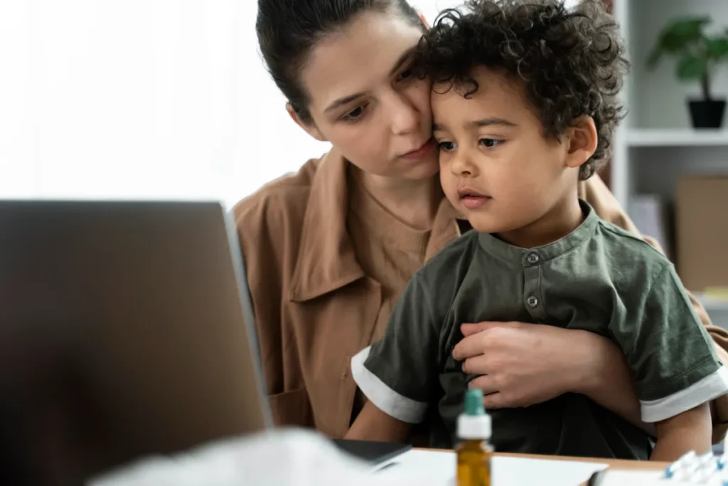 Mother holding young child while reviewing information online about child support