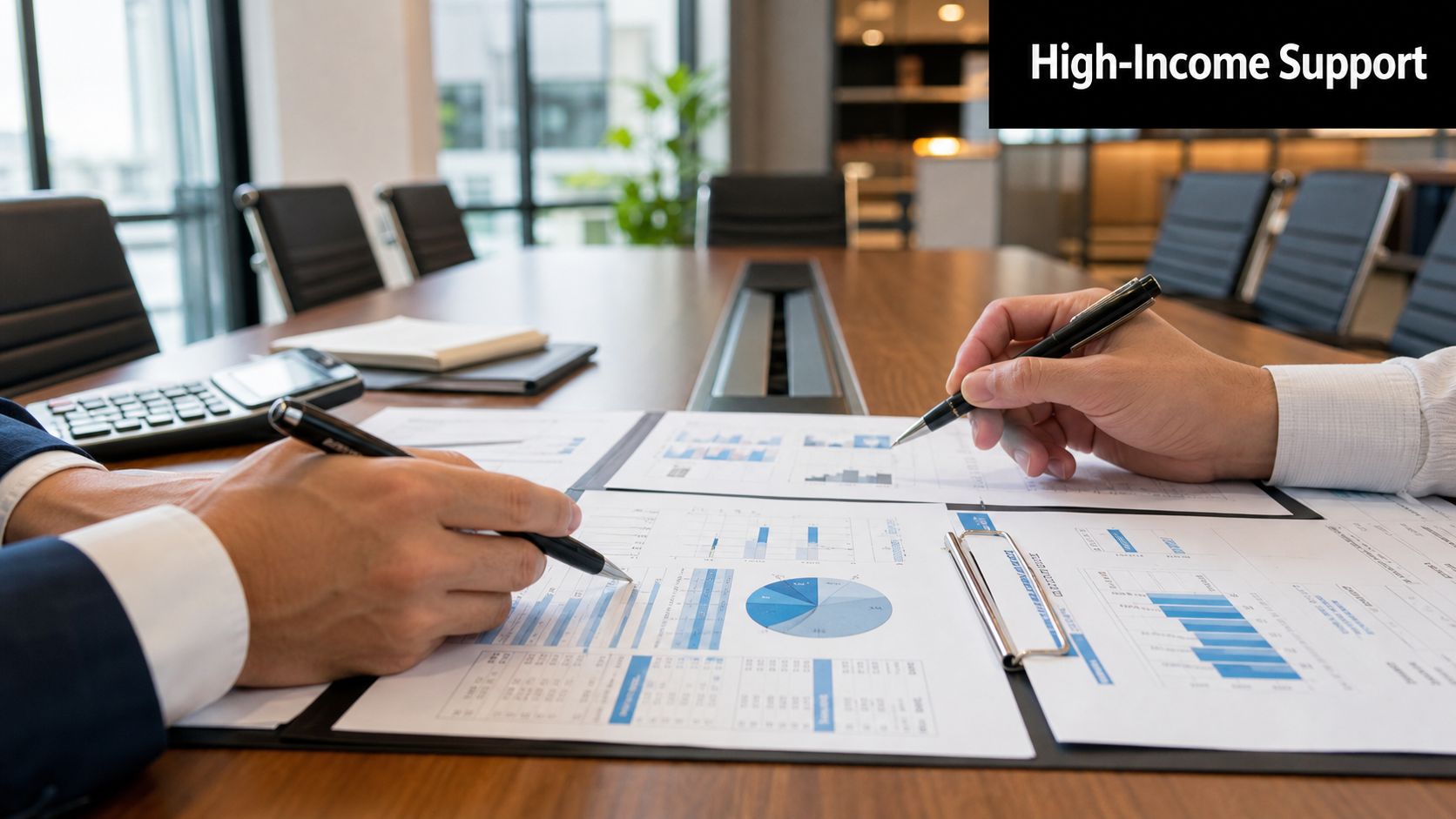 Two professionals in suits reviewing business financial reports and charts at a boardroom table.