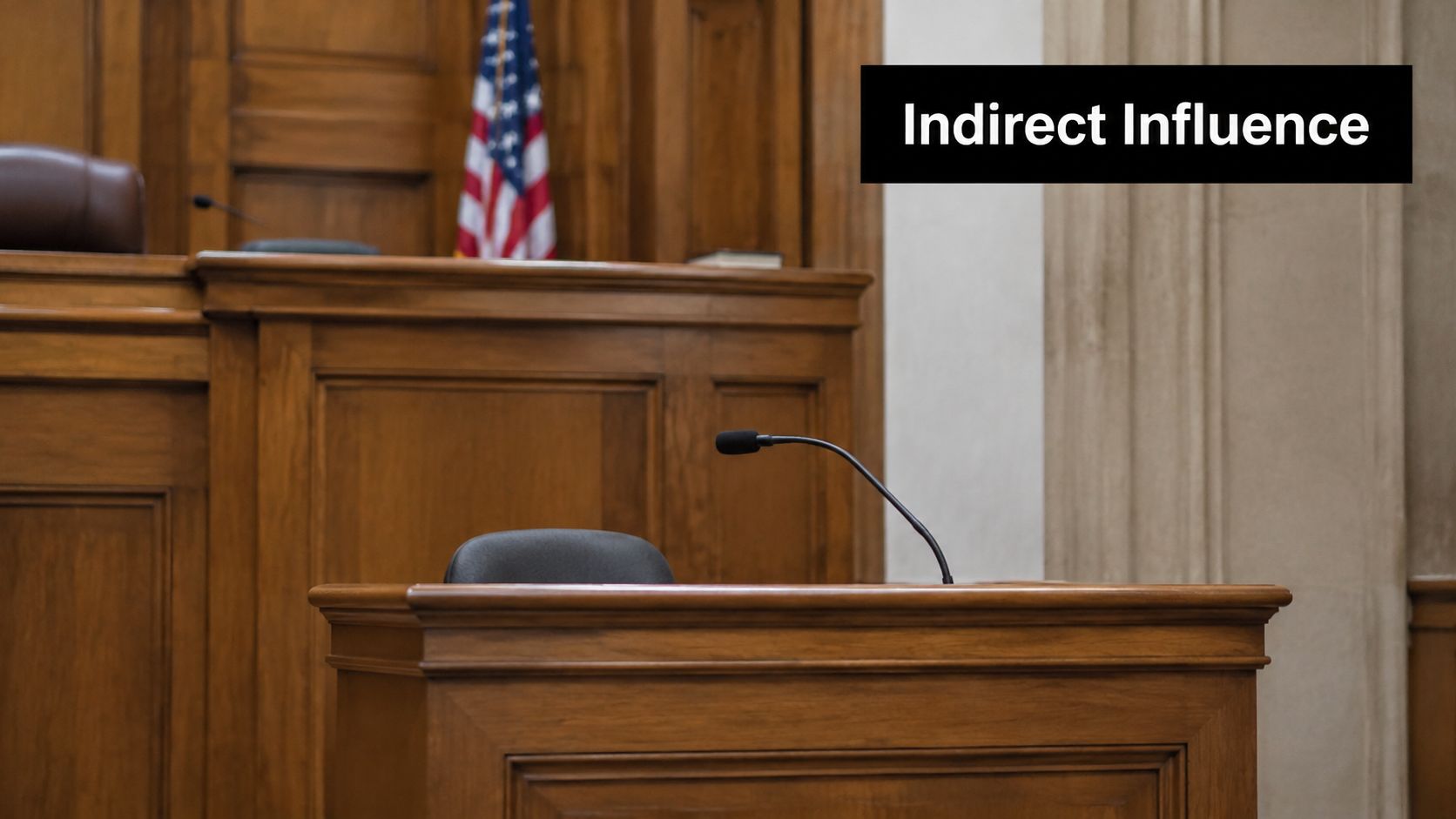 A witness stand and microphone inside a courtroom with the American flag in the background.
